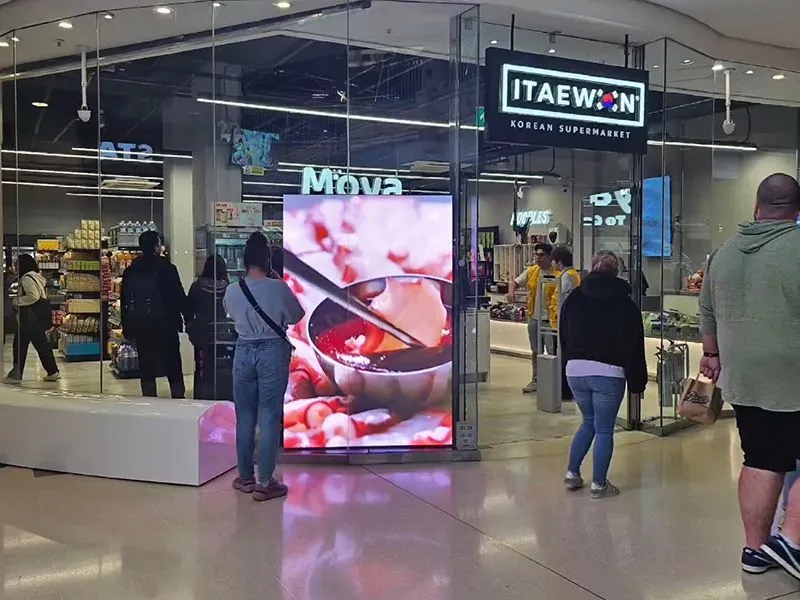 Freestanding indoor LED display showing advertising in a shopping centre