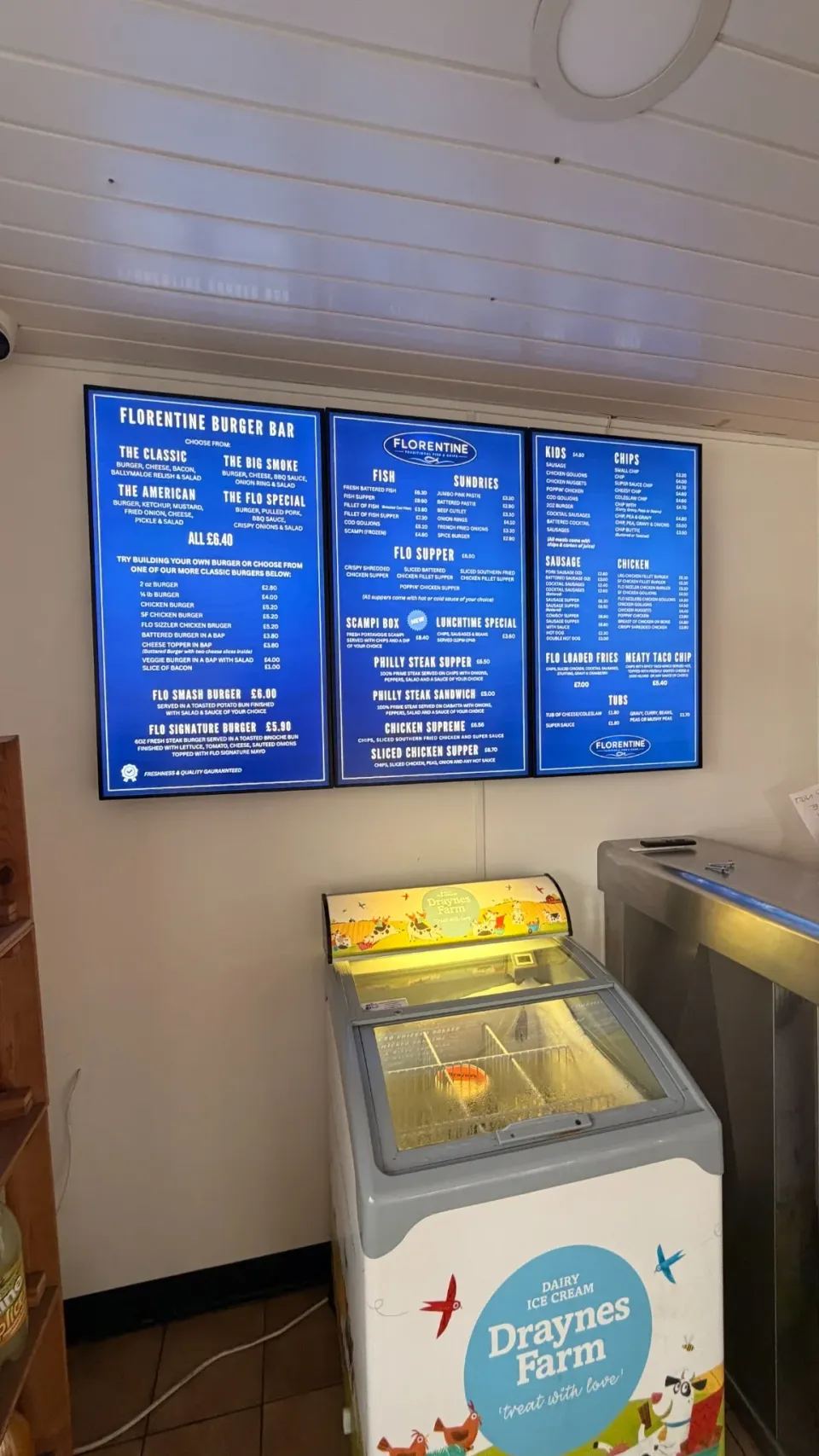 Three portrait digital menu screens above the freezer at Florentines Banbridge
